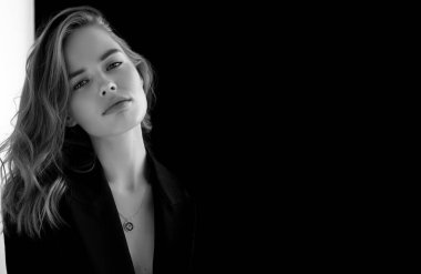 Doğal görünüş. Güzel model kadın. Gri arka planda poz veren genç ve güzel bir model ile model test portresi. Siyah ceketli sarışın bir kadın. Doğal makyaj.