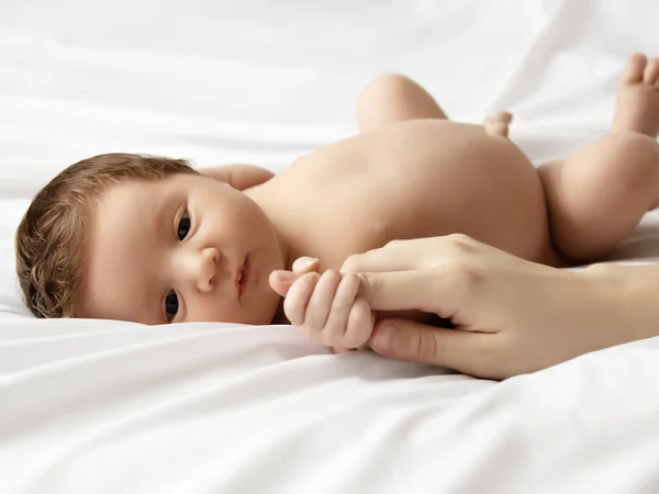 Mãe segurando a cabeça do bebê nas mãos seguras. Cuidado com as mães. Mães mão atordoando dormindo bebê cabeça durante o dia dormir na cama em casa. Mamãe cuidando de seu bebê infantil enquanto ele dorme pacificamente — Fotografia de Stock