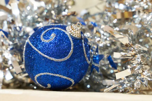 Μια Μπλε Λαμπερή Μπάλα Της Πρωτοχρονιάς Βρίσκεται Ένα Ασημί Κοντινό — Φωτογραφία Αρχείου