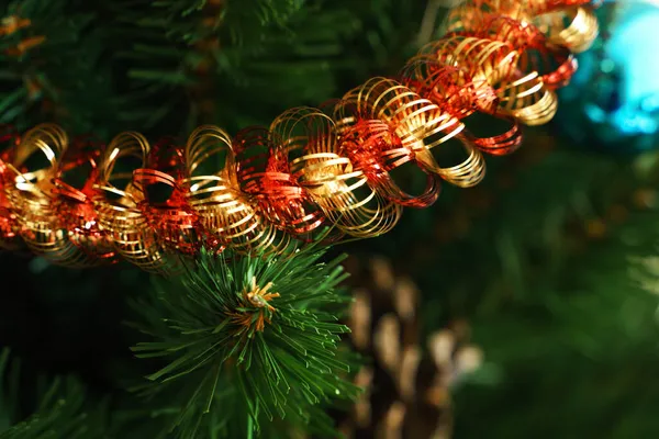 在一棵人造圣诞树的绿枝和针叶的衬托下 金红色的金光闪烁着 — 图库照片
