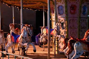 Akşamları atlarla çalışan atlıkarınca renkli ışıkta, gece fotoğrafı.