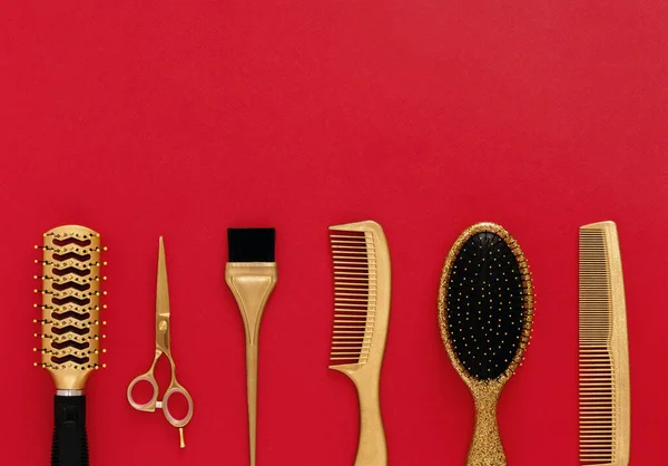 Bakgrund med frisör verktyg på rött. Hårsalong tillbehör guld, hår kammar, sax. Banner och mall för design med utrymme för text. — Stockfoto