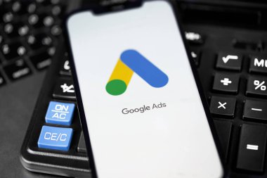 Google Ads (AdWords) logo mobile app on screen smartphone iPhone with calculator keyboard. Google services. Google Ads is a contextual service, mainly search advertising from Google. Moscow, Russia -  July 26, 2021