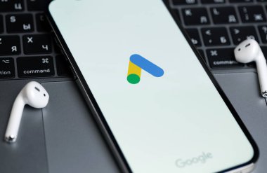 Google Ads (AdWords) logo mobile app on screen smartphone iPhone with Macbook, AirPods. Google Ads is a contextual service, mainly search advertising from Google. Moscow, Russia -  July 21, 2021