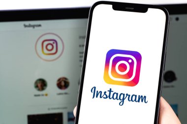 Instagram logo mobile app on screen smartphone iPhone with Macbook. Instagram is a photo-sharing app for smartphones. Moscow, Russia - July 22, 2021