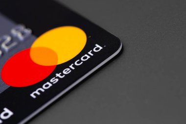 MasterCard logo plastic electronic card on grey background closeup, macro. MasterCard worldwide is an American multinational financial services corporation. Moscow, Russia - September 11, 2021 clipart