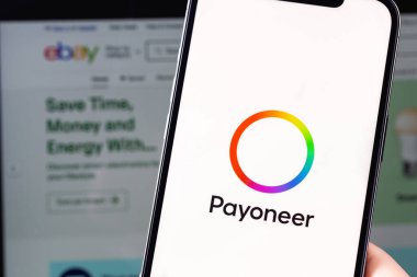 Payoneer logo mobile app on screen smartphone iPhone and MacBook with eBay website closeup. eBay Inc. a company providing services in the areas of online auctions and online stores. Moscow, Russia -  July 28, 2021