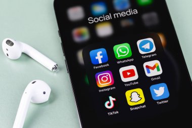showing social media apps Facebook, WhatsApp, Telegram, Instagram, YouTube, Gmail, TikTok, Snapchat, Twitter - apps on screen smartphone iPhone with AirPods, Macbook closeup. Moscow, Russia -  July 27, 2021