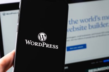 WordPress logo on screen smartphone iPhone and Macbook display closeup. WordPress - open source site content management system. Moscow, Russia - June 22, 2021