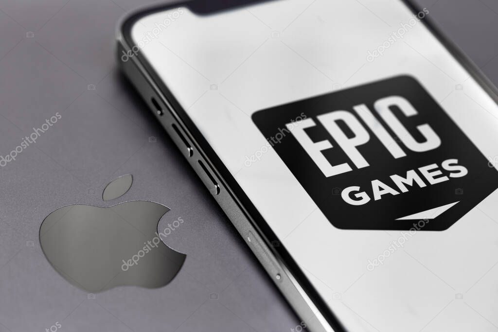Epic Games logo on screen smartphone iPhone with Apple logo closeup. Apple is a multinational technology company. Moscow, Russia -  August 25, 2021