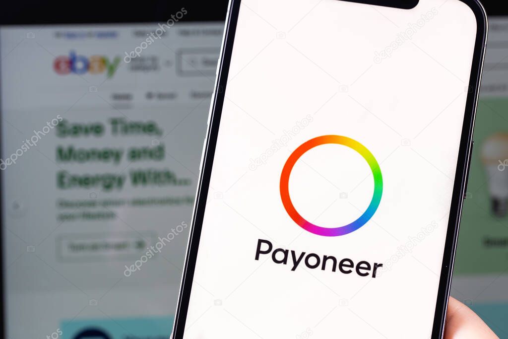 Payoneer logo mobile app on screen smartphone iPhone and MacBook with eBay website closeup. eBay Inc. a company providing services in the areas of online auctions and online stores. Moscow, Russia -  July 28, 2021