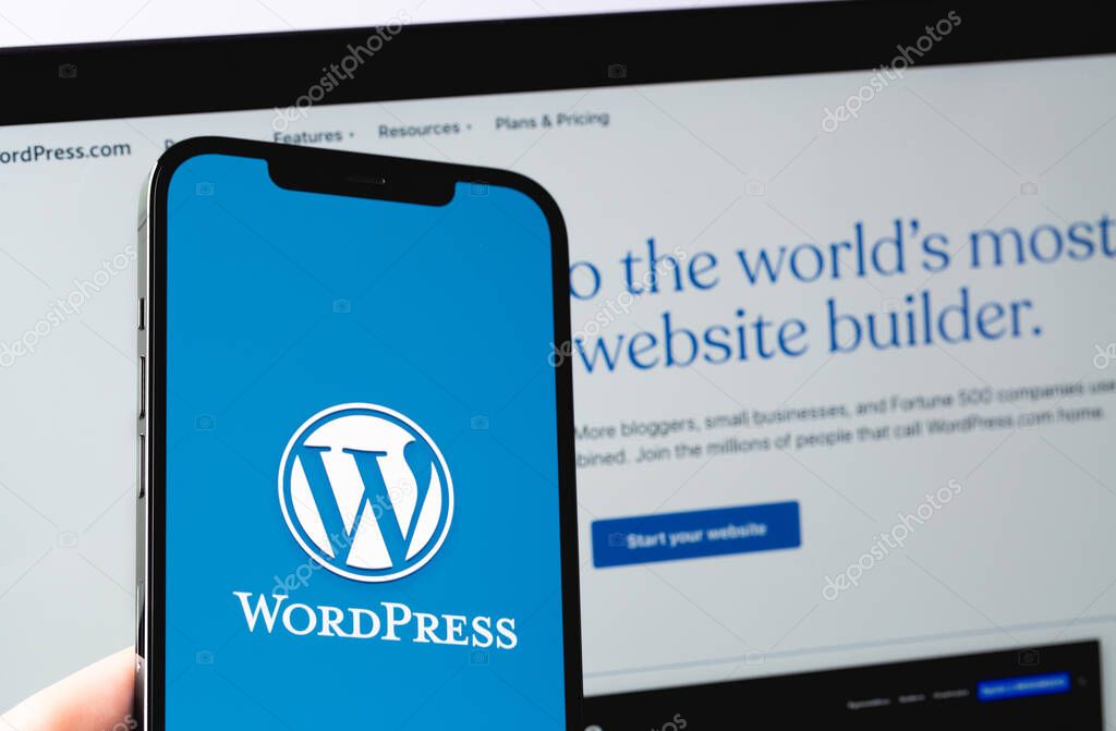 WordPress logo mobile app on screen smartphone iPhone with Macbook display closeup. WordPress - open source site content management system. Moscow, Russia - June 22, 2021