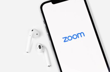 Zoom mobile logo app on screen smartphone iPhone with AirPods. Zoom Video Communications is a company that provides remote conferencing services. Moscow, Russia - June 12, 2021