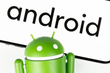 Google Android figure and smartphone displayed text Android. Google Android is the operating system for smartphones, tablet computers, e-books and other devices. Moscow, Russia - September 10, 2021