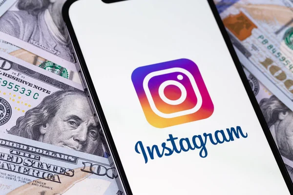 Instagram logo mobile app on screen smartphone iPhone with dollars, money closeup. Instagram is a photo-sharing app for smartphones. Moscow, Russia - September 27, 2021