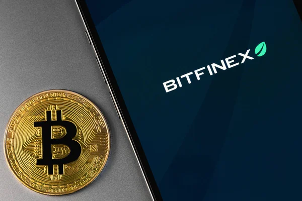 Bitfinex logo of exchange on screen smartphone with bitcoin. Bitfinex is cryptocurrency exchange on the market. Moscow, Russia - October 14, 2021