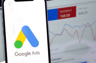 Google Ads logo on screen smartphone iPhone and display notebook closeup. Ads is a service of contextual, basically, search advertising from Google. Moscow, Russia - January 17, 2022
