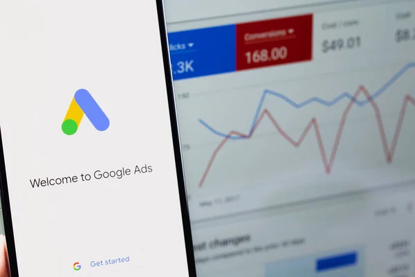 Google Ads mobile app on screen smartphone iPhone and display notebook closeup. Ads is a service of contextual, basically, search advertising from Google. Moscow, Russia - January 17, 2022