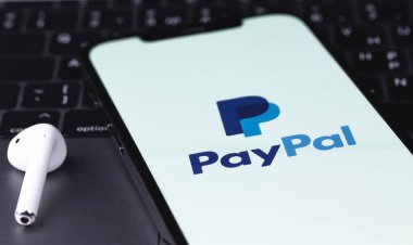 PayPal logo mobile app on screen smartphone iPhone with AirPods and Macbook. Paypal is an internet based digital money transfer service. Batumi, Georgia - March 4, 2022