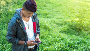Cep telefonu elinde, cep telefonu beyaz ekranlı, cep telefonu elinde fotokopi uzayı olan genç bir adama yakın durun.