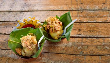 Tahta bir masada sunulan yapraklı Vigoron, tahta arka planda sunulan iki canlılık, Nikaragua 'nın tipik yiyeceği.