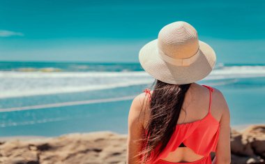 Denize bakan şapkalı bir kadın, denize bakan şapkalı bir kız, tatil konsepti, denizi izleyen bir kızın dikiz aynası.