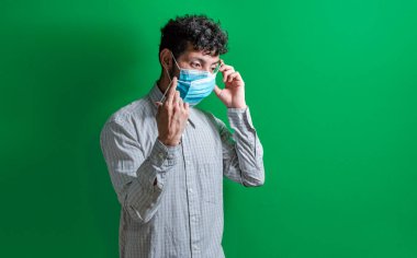 Çift maske takan bir adam, çift maske takan genç bir adam, Covid19 'a karşı harekete geçen genç bir adam.