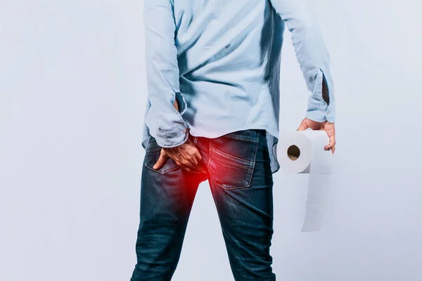 手拿着卫生纸摸着臀部的男人 有腹泻问题的男人 有痔疮问题的男人 — 图库照片