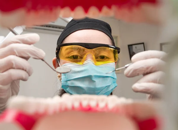 A dentist cleaning a mouth inside view, Inside view of a mouth checked by a dentist, a female dentist checking a patient. dentist checking a mouth, a dentist cleaning teeth.