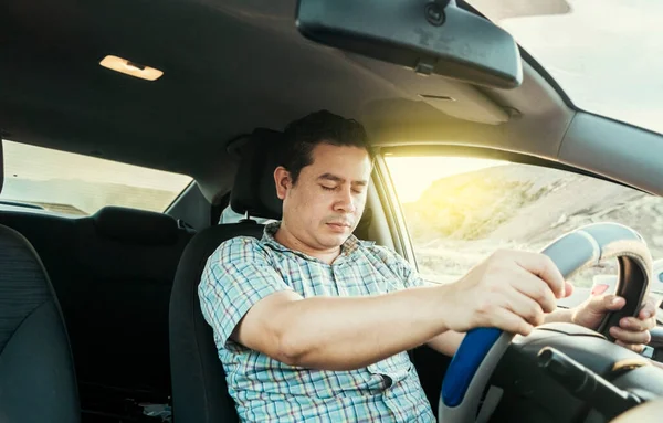 View of a driver asleep at the wheel. Tired driver with closed eyes at the wheel, concept of man asleep while driving. A drowsy driver at the wheel, a tired person while driving