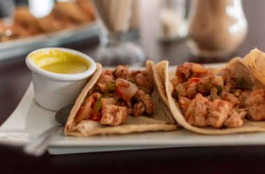 Masada salsa soslu Meksika usulü tavuk tacoları ve pico de gallo, masada servis edilen tavuklu taco manzarası. Meksika usulü tavuklu tako servisi.