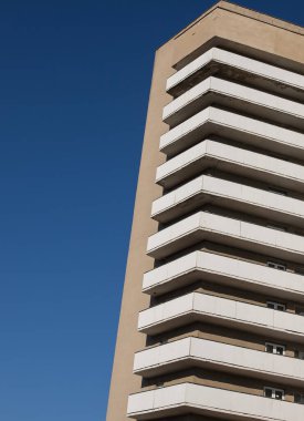 Temiz, mavi gökyüzüne karşı modern mimari geometrisi. Minimalist estetik. Mimarinin geometrik renkli şekilleri. Metin için yer