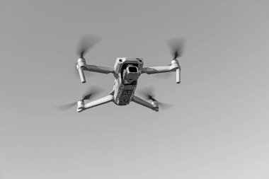 Havada uçan küçük bir dronun yakın çekim görüntüsü. Metin için yer.