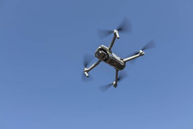 bottom close-up view of a small drone flying in the air. clipart