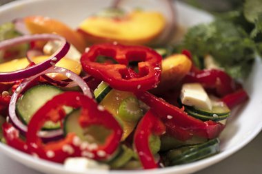 Biber salatası, salatalık, şeftali, kereviz, kırmızı soğan ve susam tohumu. Vejetaryen yemeği ve atıştırmalıklar. Temiz yemek, çiğ yemek, detoks, bitki temelli diyet konsepti.