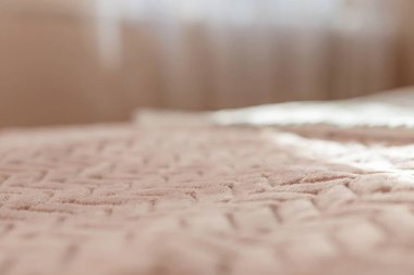 Otel odasındaki sabah üstü örtülü yatağın manzarası. Sabah güneşinde. Sıcak sabah atmosferi. Uyumak için çarşaf. Yüzeyin derinliği. Seçici odaklanma. renk 2022,