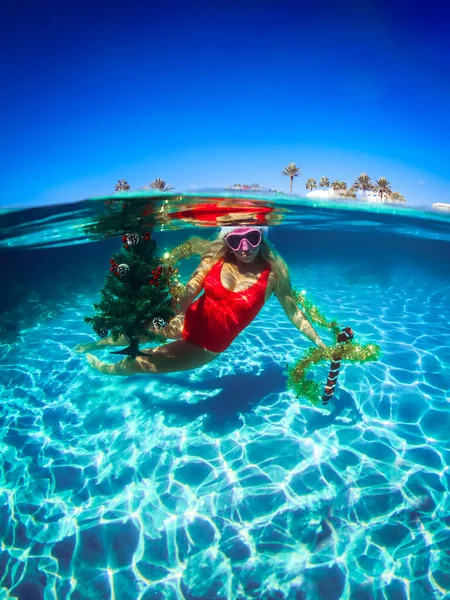 Femme plongeuse libre en maillot de bain rouge avec sapin de Noël, sous-marin, plongée sous-marine dans l'océan — Photo