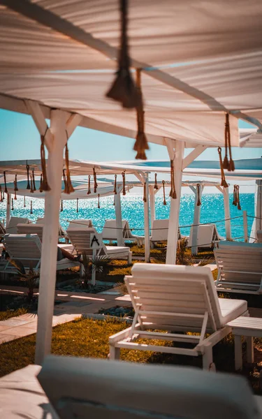Foto av vit solarium med turkos Medelhavet på bakgrunden sommar semester tropiska Stockfoto