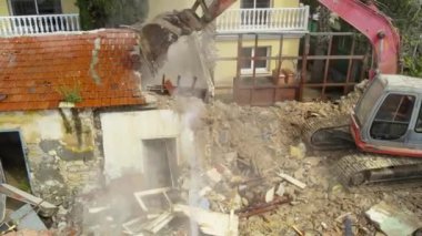 Hidrolik ezici kazıyıcı ve yıkıcı ile küçük eski bina evini yıkmak.