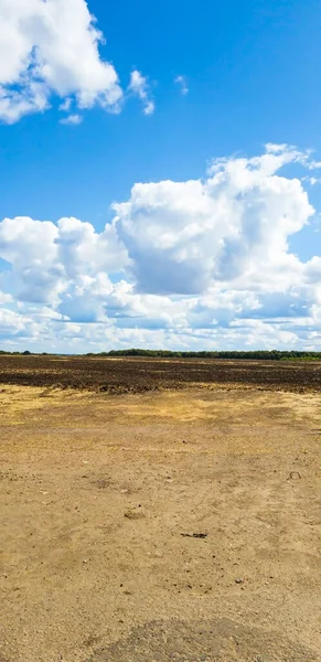 Блакитне небо з хмарами на тлі поля і брудної дороги — стокове фото