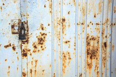 Eski metal kapı yeni bir siyah kilitle kaplanmış..