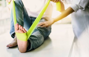 Hemşireler hastalara bacak kası zayıflığının tedavisi için esneklik egzersizleri yaparak esneme egzersizleri yapmalarında yardımcı olur..