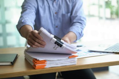 Belge yığınıyla çalışan bir işadamı.