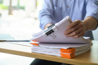 Kopya alanı olan belge yığınıyla çalışan işadamı.