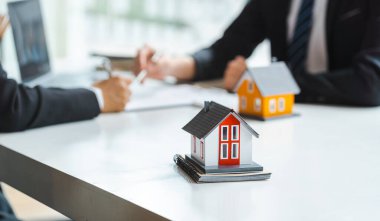 işadamı işaretler sözleşme arkasında ev mimari modeli.