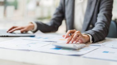 Modern ofis, muhasebeci ve vergi konseptinde hesap makinesi ve dizüstü bilgisayar kullanarak kadın ellerini kapat.