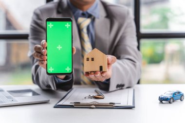 Boş ekran cep telefonu, ev modeli ve arabası olan işadamı vergi borcu için ya da yeni bir iş adamı.