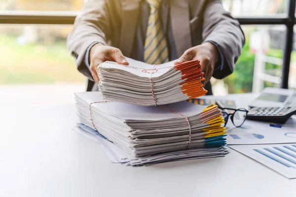 Stack of documents, pile of papers on office desk employee\'s table, closeup, Asian people.