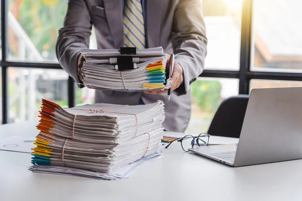 Stack of documents, pile of papers on office desk employee\'s table, closeup, Asian people.