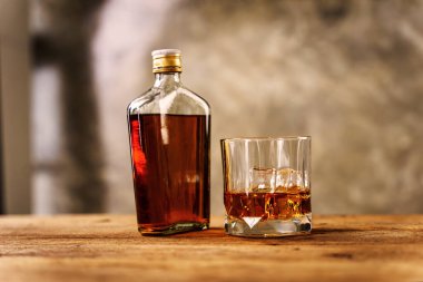 Yansıtıcı siyah yüzeyinde buz küpleri olan bir bardakta Wiskey. Bar içme menüsü